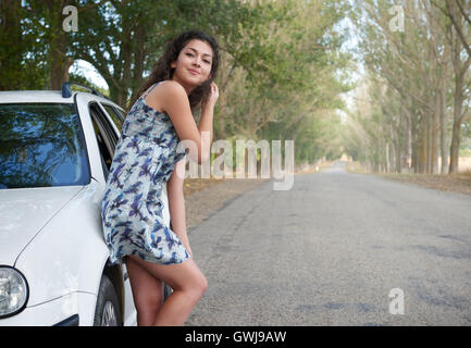 Girl on country road avec voiture, saison d'été Banque D'Images