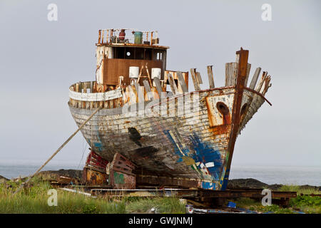 Old rusty chalutier de pêche étant cassée vers le haut sur la rive, bow à l'appareil photo Banque D'Images