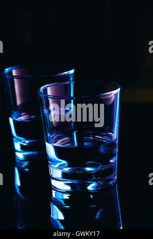 Verres à boire sur un fond sombre. Banque D'Images