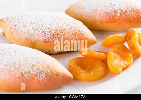 Galettes avec des abricots séchés sur plaque blanche. Banque D'Images