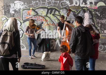 Une paire de musiciens aux spectacles sur Clink Street, Londres, vu par des passants Banque D'Images