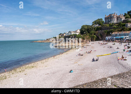 Les vacanciers à bronzer sur la plage à Brixham sous le soleil d'été Banque D'Images