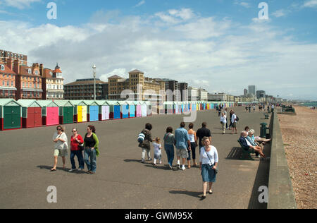 Des cabines de plage et des piétons sur l'estran de Brighton et Hove, East Sussex, UK Banque D'Images