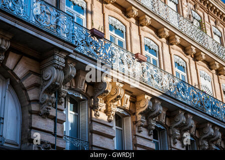 Façade ornée d'un bâtiment avec des balcons en fer forgé et des ombres de maisons d'en face à Toulouse, France Banque D'Images