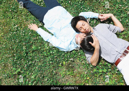 Jeune homme couple japonais portant sur l'herbe Banque D'Images