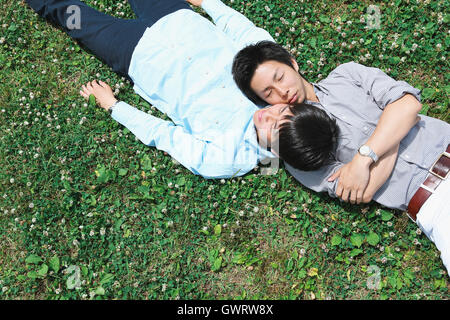 Jeune homme couple japonais portant sur l'herbe Banque D'Images