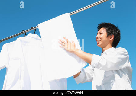 Jeune homme japonais faisant la blanchisserie Banque D'Images