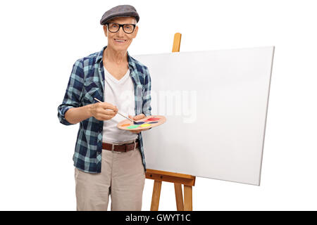 Peintre posant à côté de maturité une toile blanche isolé sur fond blanc Banque D'Images