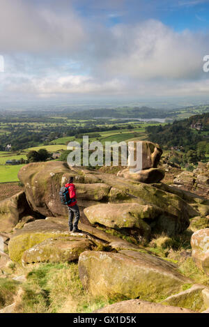 Un marcheur se tenait sur Ramshaw Rocks à la poule vers Cloud à l'Roaches, parc national de Peak District, Staffordshire. Banque D'Images