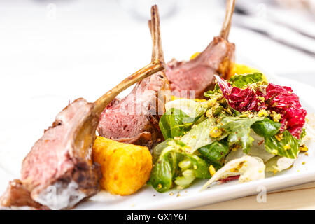 De l'agneau grillé servi sur purée de pommes de terre avec une salade fraîche et croquette Banque D'Images