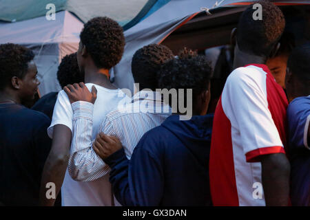 Rome, Italie. 14 septembre 2016. Les réfugiés la queue au point de distribution de nourriture pour le dîner. De nombreux réfugiés escale à Rome, où beaucoup de dormir dans la rue, sur le chemin de la Sicile à la frontière dans le nord. De nombreux réfugiés aussi retourner dans le nord de l'Italie à Rome, comme les frontières de la Suisse et la France sont effectivement fermé. Les bénévoles de l'expérience de baobab fournissent les réfugiés avec des repas réguliers à l'aide de l'Association près de la gare Tiburtina. Crédit : Michael Debets/Alamy Live News Banque D'Images