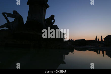 Würzburg, Allemagne. 14Th Sep 2016. La Franconie Fontaine avec les chiffres décrivant les Walther von der Vogelweide (R) et Matthias Gruenewald ainsi que les réflexions de la cathédrale de Würzburg towers vu au cours de l'heure bleue à Würzburg, Allemagne, 14 septembre 2016. Photo : Karl-Josef Opim/dpa/Alamy Live News Banque D'Images