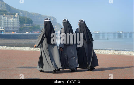 Les FEMMES DANS LES VÊTEMENTS RELIGIEUX MARCHE SUR LA MER DE LA DIVERSITÉ ETHNIQUE DE LA COMMUNAUTÉ CULTURELLE MULTI STYLE BURKA COUVRE-CHEF COUVERTS UK Banque D'Images