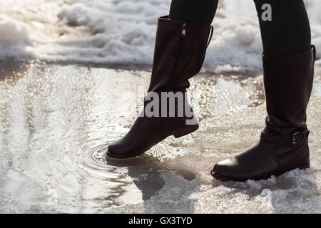 Bottes filles jambes en essayant d'aller sur flaque à snow Banque D'Images