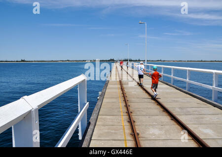 Australia-January,Busselton WA,15,2016:Les enfants en équilibre sur fer sur Busselton Jetty auprès des touristes et de l'eau de mer à Busselton, Australie de l'Ouest. Banque D'Images