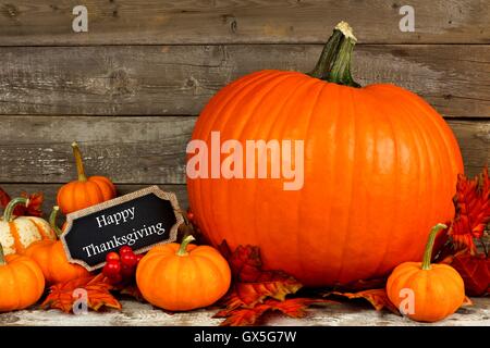 Citrouilles d'automne avec happy thanksgiving tableau tag contre un arrière-plan en bois rustique Banque D'Images