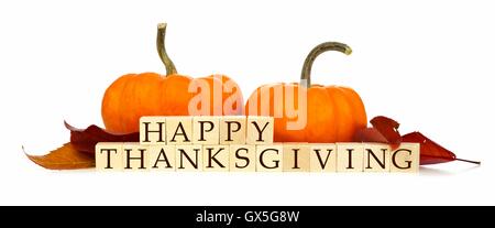 Joyeux Thanksgiving blocs en bois avec les citrouilles et les feuilles d'automne isolated on white Banque D'Images