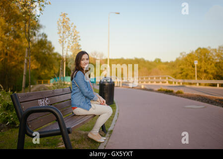 La belle ville jeune femme assise sur un banc dans la ville Banque D'Images