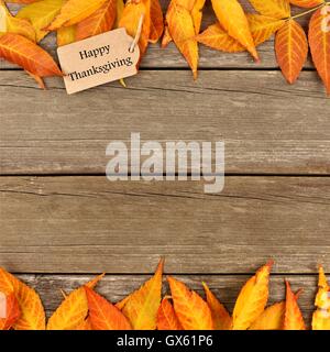 Joyeux Thanksgiving gift tag with double bordure de feuilles aux couleurs automnales sur un fond de bois rustique Banque D'Images