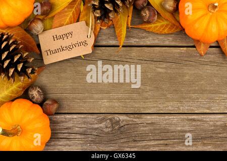 Joyeux Thanksgiving gift tag with corner border de feuilles colorées et des citrouilles sur un fond de bois rustique Banque D'Images
