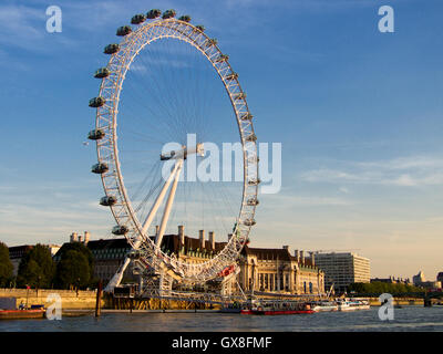 Vue sur le London Eye et le County Hall à partir de la rivière Thames, dans la soirée, Londres, Angleterre Banque D'Images