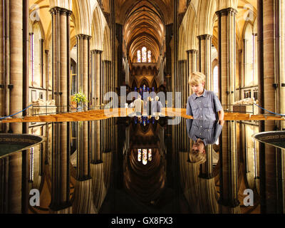 Nef et font de la cathédrale de Salisbury avec un jeune garçon à la police, à Salisbury, Angleterre Banque D'Images