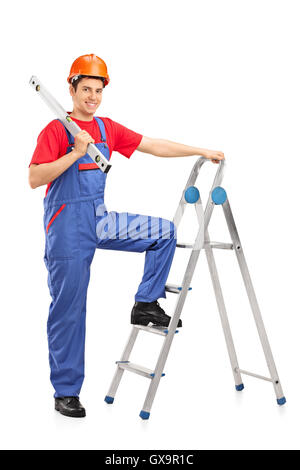 Construction Worker posing sur une échelle isolé sur fond blanc Banque D'Images