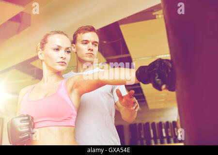 Femme avec un entraîneur personnel dans la salle de sport de boxe Banque D'Images