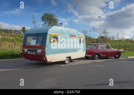 Remorque caravane tradition depuis les années 1960 il est remorqué par une vieille voiture à partir de la même période, stationnée à une autoroute Banque D'Images