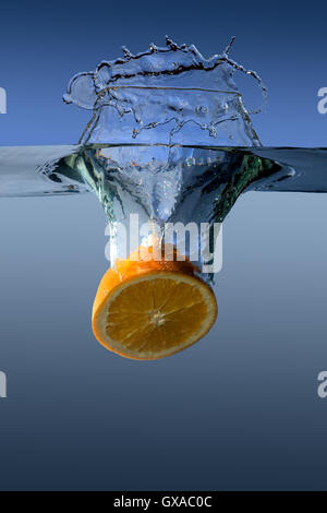 Chutes dans l'eau d'Orange sur un fond bleu Banque D'Images