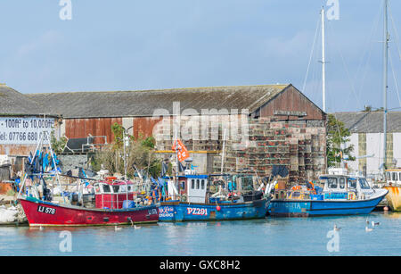 Plusieurs petits bateaux de pêche amarrés sur une rivière au Royaume-Uni. Banque D'Images