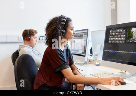 Jeune femme designer assistée par ordinateur travaillant sur ordinateur en design studio Banque D'Images