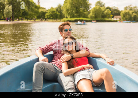 Jeune couple romantique en bateau à rames inclinables dans Regents Park, London, UK Banque D'Images