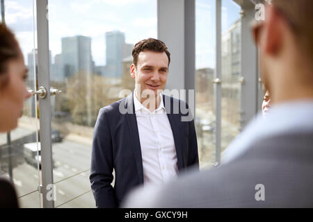 Plus d'épaule d'hommes et de femmes d'affaires et avoir la discussion sur la passerelle de la ville, Londres, UK Banque D'Images