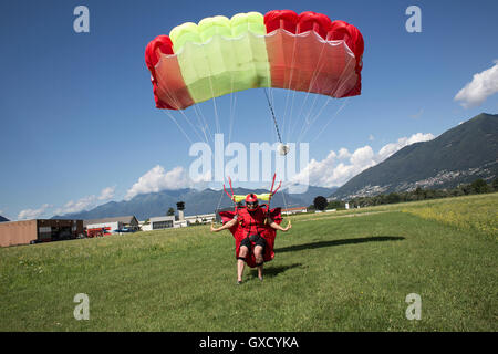 Parachute atterrissage parachutiste sur terrain. Direction et ralentissant sa verrière en tirant pause bascule, Locarno, Tessin, Suisse Banque D'Images