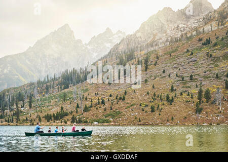 Famille de quatre enfants paddling canoe on lake, Grand Teton National Park, Wyoming, USA Banque D'Images