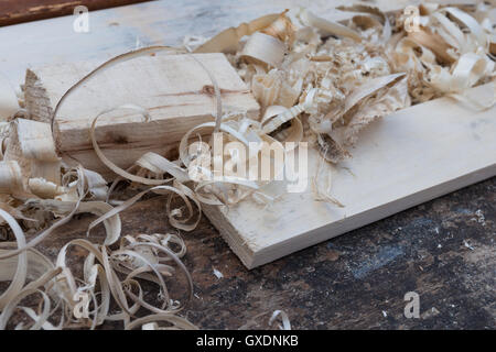 Copeaux de bois frais et quelques planches en bois sur un banc de menuisier. Le travail du menuisier traditionnel. Personne autour. Banque D'Images