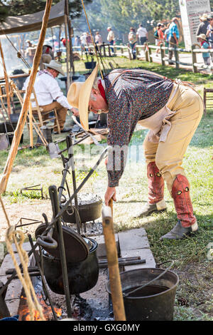 Un vieux cowboy cuisinier prépare un repas au cours d'une compétition de chariots au cours de Cheyenne Frontier Days le 25 juillet 2015 à Cheyenne, Wyoming. Frontier Days célèbre les traditions de l'ouest cowboy avec un rodéo, défilé et juste. Banque D'Images
