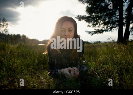 Caucasian girl laying in grass field Banque D'Images