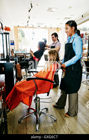 Coiffeurs et clients dans un salon de coiffure Banque D'Images