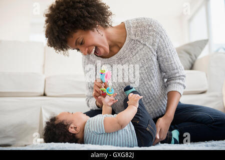 Mère jouant avec son bébé sur le plancher Banque D'Images