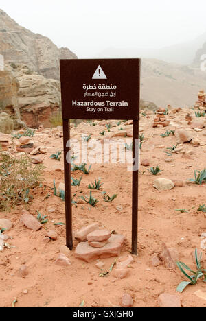 Avertissement pour les touristes leur demandant de rester sur la piste car il y a des terrains dangereux tout autour, Petra, Jordanie. Une destination touristique célèbre Banque D'Images