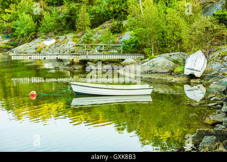 La barque en plastique ouverts dans la région côtière de paysage sur la côte occidentale de la Suède. Pier et autres bateaux à terre en arrière-plan. Banque D'Images