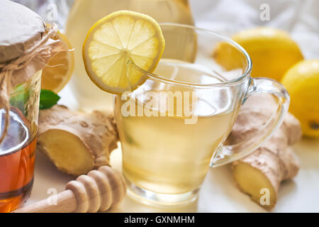 Thé au gingembre servi avec du miel, citron et menthe sur tableau blanc Banque D'Images