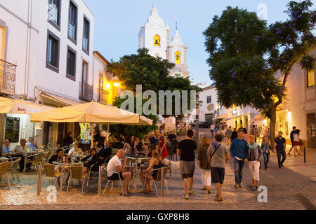 Les gens assis à la terrasse d'un café en plein air en début de soirée, la vieille ville de Lagos, Algarve, Portugal Europe Banque D'Images