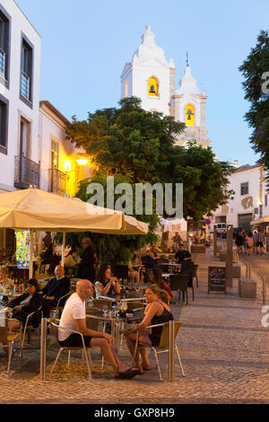 Les gens assis à la terrasse d'un café en plein air en début de soirée, la vieille ville de Lagos, Algarve, Portugal Europe Banque D'Images