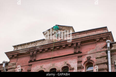 Constructeur-climber hanging sur le haut de la façade d'un bâtiment Banque D'Images