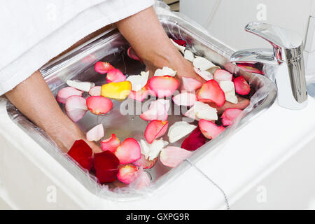 Baignoire avec des pétales de rose dans une pédicure Banque D'Images