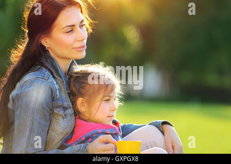 Portrait de mère à fille de détente en plein air, passer du temps ensemble à jour d'automne chaud et ensoleillé, aimant happy family Banque D'Images