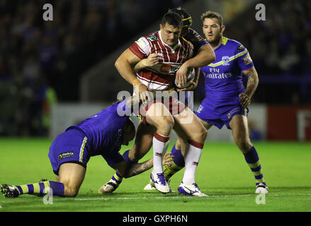 Wigan Warriors Ben fleur est abordé par Warrington Wolves' Ashton Sims (à gauche) et Chris Hill (à droite) pendant le Super 8 match au stade Halliwell Jones, Warrington. Banque D'Images